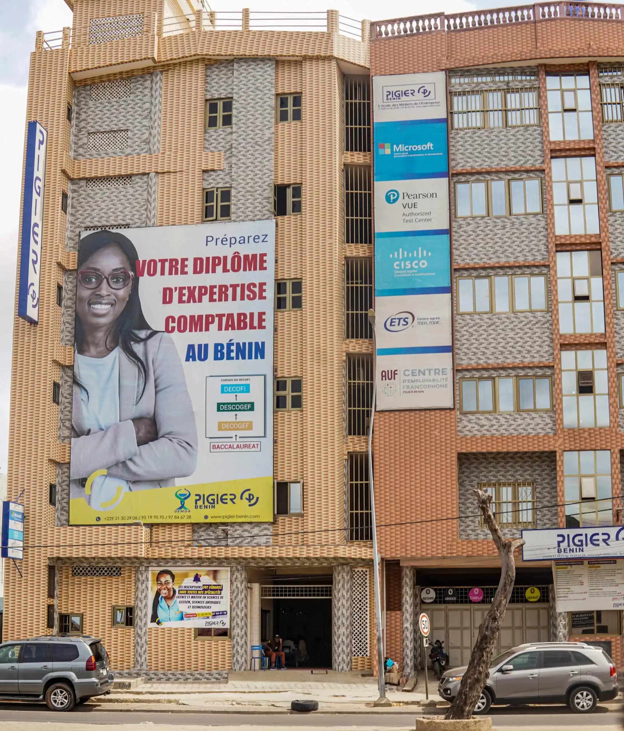 Le siège de Pigier-Bénin à Agontinkon, Cotonou : immeuble R+5 avec les enseignes des centres agréés Microsoft, Pearson VUE, Cisco, ETS et AUF